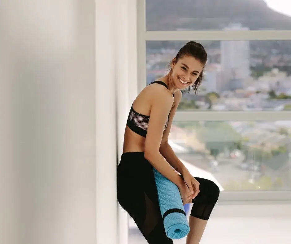 Person after a workout holding a yoga mat — active and healthy lifestyle without alcohol.