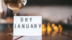 Schriftzug „Dry January“ auf einer beleuchteten Box auf einem Tisch, Symbol für einen alkoholfreien Monat und bewusste Entscheidung