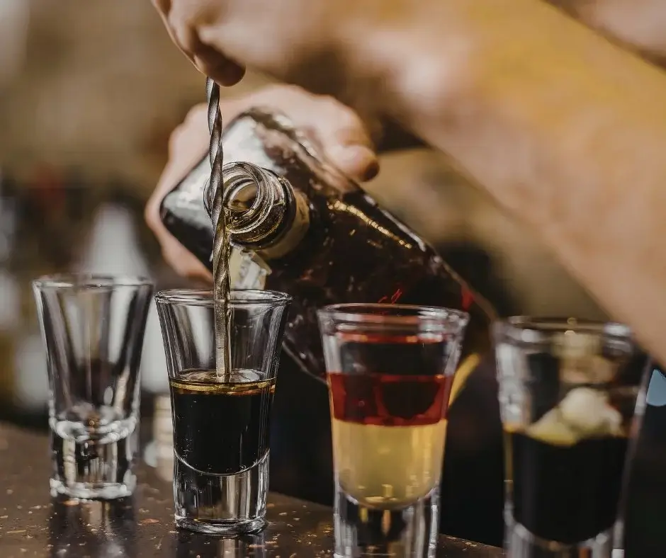 Pouring an alcohol-free drink into a shot glass – preparing a zero proof drink and example of proper serving proportions